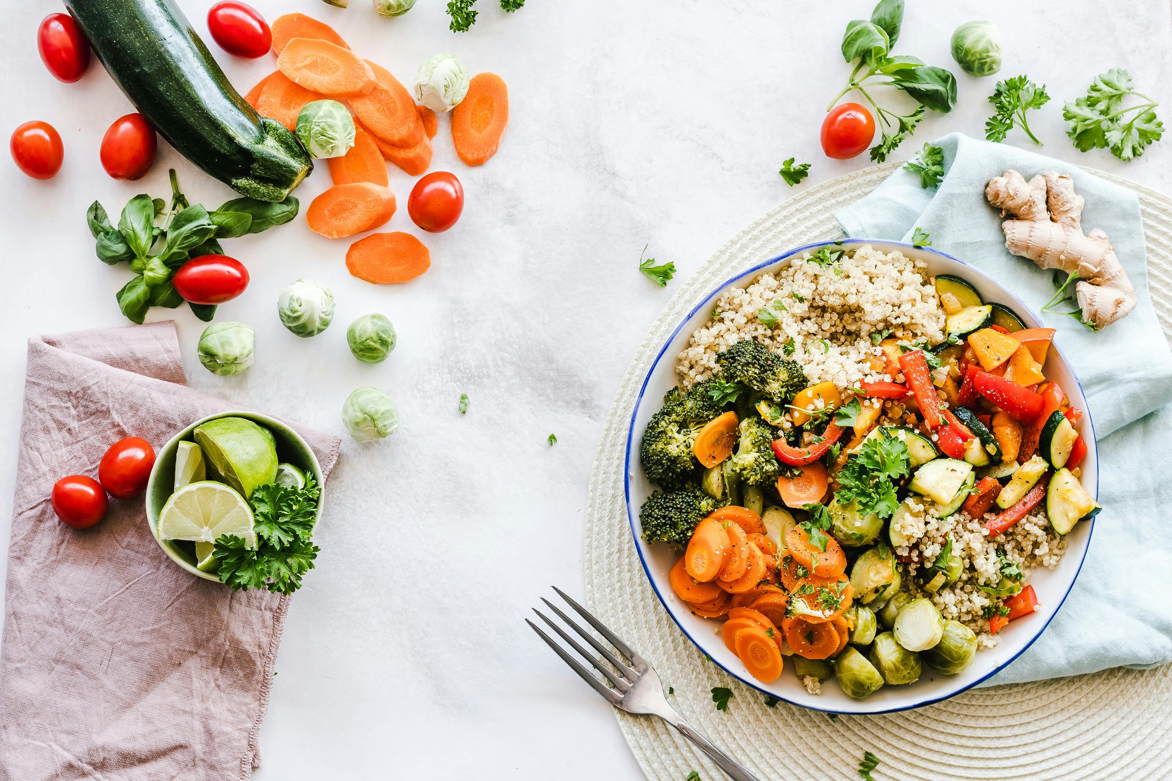 Gezonde groentesalade met quinoa in wit keramisch bord op lichte, minimalistische tafel. Gezond eten en vegetarisch concept.